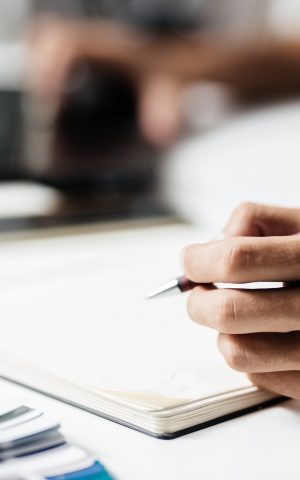 Man makes notes in a notebook on a table